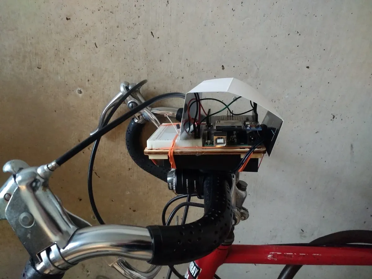 Arduino-based biometric mapper mounted on bike handlebars with paper shield covering electronics.